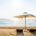 plage ensoleillée avec deux transats et un parasol