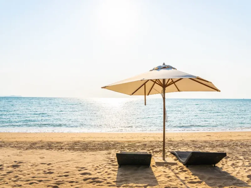 plage ensoleillée avec deux transats et un parasol