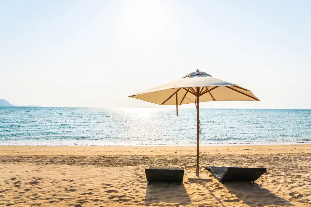 plage ensoleillée avec deux transats et un parasol