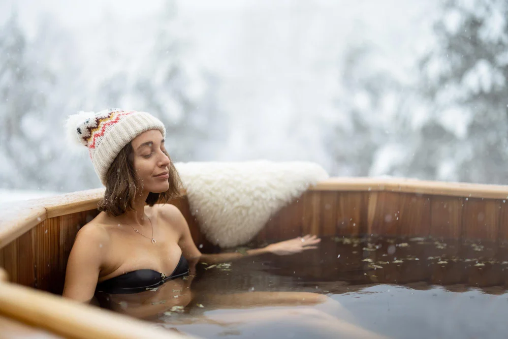 femme se relaxant dans un bain chaud extérieur sous la neige