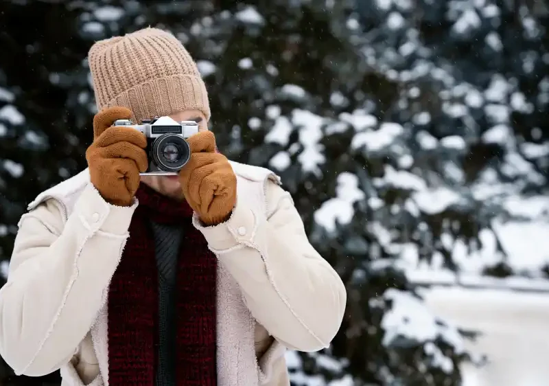 photographe prenant des photos dans un paysage enneigé