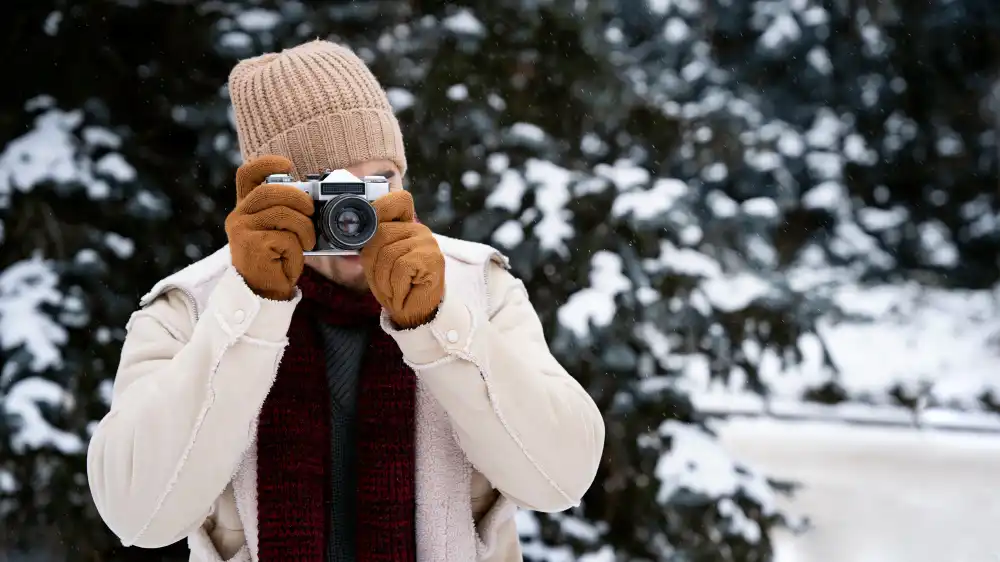 photographe prenant des photos dans un paysage enneigé