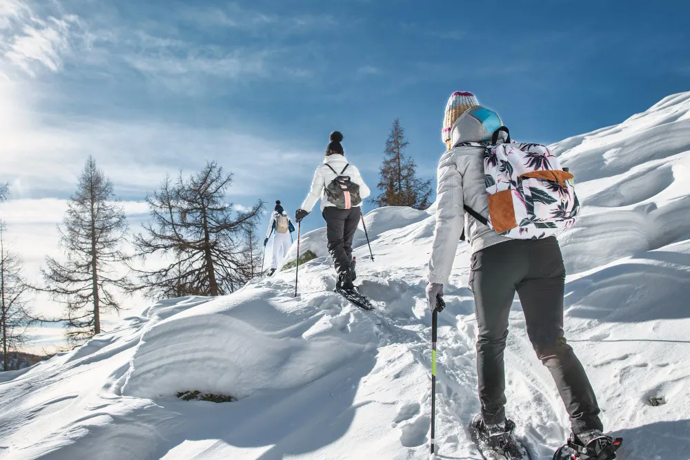 3 femmes faisant des raquettes en montagne